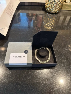 Silverfärgad kedjearmband  - Snyggt och stilrent armband från Trendhim, modell Lucleon. Armbandet är silverfärgat med en klassisk kedjedesign och har ett smidigt lås. Perfekt accessoar för att lyfta din outfit med en modern touch. Nypris 800 kr mitt pris 400 kr 