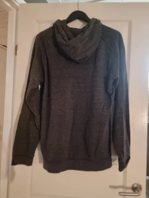 Grå hoodie från h&m - En grå hoodie från h&m med en mitten ficka 