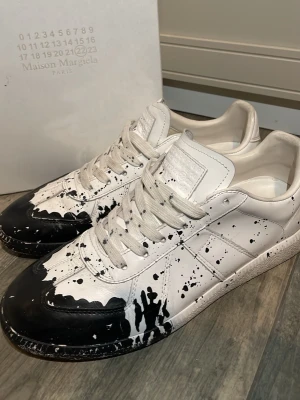 Maison Margiela GATS - Säljer dessa tvärfeta skorna från Maison Margiela då dom är lite små 🔥, inte säker på om dom är äkta då jag köpte från en annan grabb på plick som inte var säker 👀. Dom är vita med svart färg vid tårna. Använt dom ca 30 gånger skulle säga skick: 7,5/10💪. Vänligen ställ frågor och priset kan sänkas vid snabb affär🍾🔥.