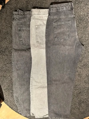 3-pack grå loose fit jeans H&M 170 - Säljer tre par gråa jeans från H&M i storlek 170. Alla har loose fit och justerbar midja, ett par har även straight leg. Färgerna varierar från ljusgrå till mörkgrå tvätt. Klassisk femficksmodell och sköna att bära till vardags.