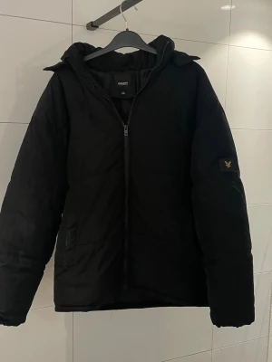 Svart Lyle & Scott Dunjacka - Perfekt jacka nu till vintern. Jackan är i fint skick och har inga tecken på slitage eller skavanker. Storleken på den är 12/13 Years, men passar även som S.