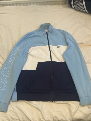 Lacoste - Mörkblå, ljusblå blå ch vit full zip kofta utan luva. Pris kan diskuteras👍