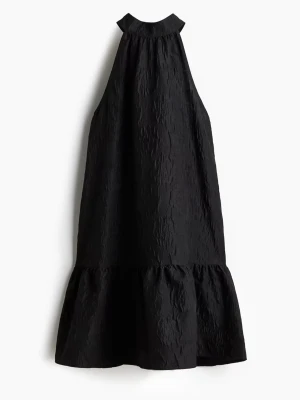 Svart jacqardvävd klänning med knytband  - Säljer min svarta klänning från H&M som är helt oanvänd, bara testad. Köpt i Köpenhamn på H&M. Säljer pga att den inte passar. Super cool svart klänning, med hög hals, knytband där bak, lite loose och rak i modellen med volang längst ned!🎀 Nypris 299 kr 