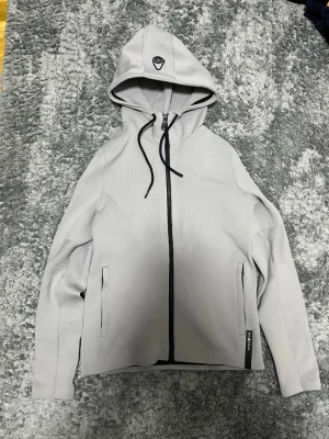 Sail Racing zip hood - En grå zip Hood från Sail Racing. Perfekt för vardagen eller för att segla.