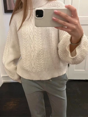 Vit polotröja med kabelstickning - Säljer en mysig vit polotröja med breda ärmar och snygg kabelstickning framtill. Tröjan har hög polokrage och är stickad i ett tjockare material som passar perfekt när det är kallt ute. Perfekt för dig som gillar en chill och stilren look. Priset kan diskuteras ❤️❤️❤️