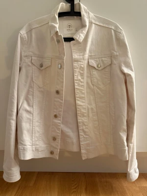 Vit jeansjacka  - Snygg vit jeansjacka från Emilio med klassisk krage, två bröstfickor med lock och silverfärgade knappar. Rak passform och stilren design som passar perfekt till många olika outfits. Storlek L men känns mer som en M/S skulle jag säga.