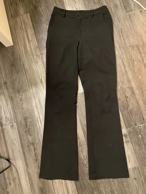 Svarta kostymbyxor från BikBok - Snygga svarta kostymbyxor från BikBok, som är vida i bena. Sitter jätte fint i passform. Är 159 och dem är perfekt långa och går över skorna. 