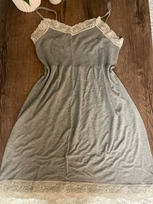 Grått nattlinne med spetsdetaljer - Grått nattlinne med söta spetsdetaljer. Köpt på Ullared Gekås för några få år sedan. Använt fåtal gånger! Passar både XS och S.