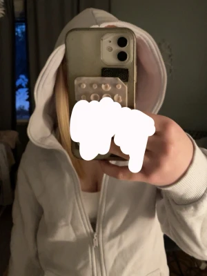 Vit zip-hoodie med huva - Snygg vit hoodie med dragkedja och huva. Modellen är klassisk med ribbade muddar och fickor på sidorna. Perfekt för en avslappnad och stilren look. Passar till det mesta och är superbekväm.