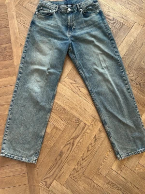 Blå jeans från Sweet Sktbs - Säljer ett par blå raka jeans från Sweet Sktbs med klassisk femficksmodell och knappgylf. Jeansen har en avslappnad passform och är tillverkade i slitstark denim. Perfekta för dig som gillar en casual och tidlös stil.
