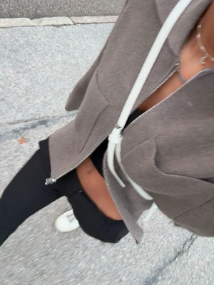 Beige ziptröja med krage - Snygg beige ziptröja med krage och två stora fickor framtill. Tröjan är croppad och har långa ärmar. Perfekt till ett par höga jeans eller byxor för en clean och modern look. Använt en gång, säljer pågrund av att jag ville att den skulle sitta tajtare 🫶🏼