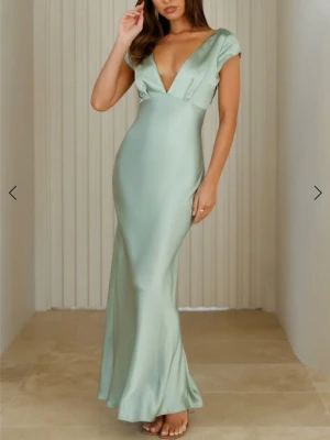 Ljusgrön långklänning i satin - Elegant ljusgrön långklänning i satin med djup v-ringning och öppen rygg. Klänningen är helt oanvänd med alla prislappar kvar. Nypris: 1400 + 100kr frakt. En perfekt och superfin balklänning som tyvärr inte passade mig!💗🥹Kan sälja för 1000 vid snabb affär!!💞