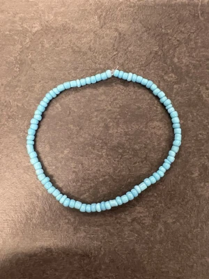 Blått pärlarmband storlek L  - Ett enkelt och stilrent armband med runda pärlor i ljusblå färg. 