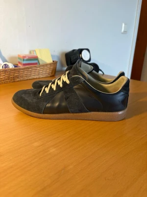 Mörkblå maison margiela gats - Säljer nu mina maison margiela eftersom dem inte passar min stil längre. Jag har haft dem i ca 4 månader och använt dem max 10 gånger försiktigt! De är i 8,3/10 i skick!  Dem är i storlek 43 men passar 44. Kvitto och Box följer självklart med! Skriv vid minsta fundering eller fråga!