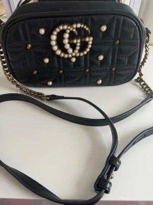 Svart axelväska från Gucci med pärldetaljer - Fattas två pärlor, fin skick 