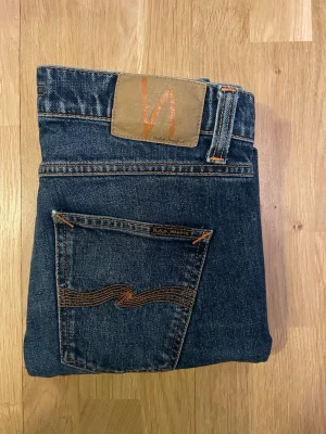 Mörkblå jeans från Nudie Jeans, strl W29 L32 - Jättesnygga jeans från Nudie jeans i storlek W29 L32. Jeansen är i jättebra skick och har inga skador. Nypris ca 1600 kr mitt pris endast 599 kr. Fraktar inom 1 dag, om du har någon fundering så är det bara att höra av sig😊