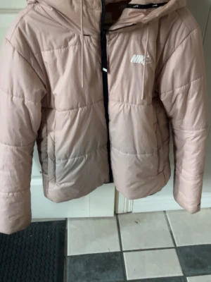 Ljusrosa nike jacka - Ljusrosa vinter/vårjacka från Nike i M, använt skick med fläck som syns på bilden, tror den går att bli av med och ser dessutom värre ut på bilden💕nypris 1100 kr