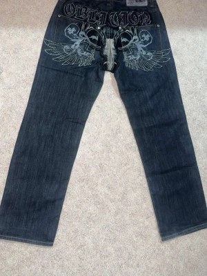 Mörkblå jeans med vingar - Mörkblå jeans med vingar detaljer,fick dom i present vet ej vad det är för märke. Dom har en baggy bassform , dom passar bra med ganska många färger. För mer frågor eller bilder skriv jättegärna ☺️