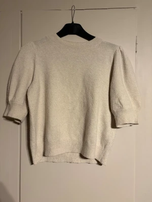 stickad tröja med puffiga ärmar - stickad tröja med puffiga ärmar från vero moda! tröjan är i beige och har en liten bronser fläck på axeln som inte märks av (se bild 2) denna tröja passar perfekt till ett par svarta jeans eller kostymbyxor