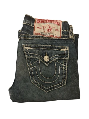 True Religion Jeans Joey Super T - True religion jeans, joey, flare / bootcut. Ganska bra skick men har en reparation vid grenen.  Storlek 31. 42cm midja, 105cm längd, 25cm ben öppning och 80cm innerben längd. Skriv om ni undrar något. 📲