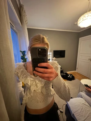 Vit spetsblus från Zara - Supersöt vit blus från Zara med långa ärmar och vackra spetsdetaljer. Blusen har volanger framtill och är stickad i ett luftigt material som ger en romantisk vibe. Perfekt att styla med jeans eller kjol för en trendig look.