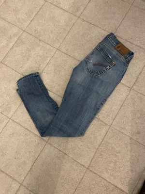 Ljusblå jeans från dondup jeans - Snygga ljusblå jeans från dondup med klassisk femficksdesign och bruna detaljer på bakfickan. Jeansen har en rak passform och är tillverkade i denim med lätt slitning för en cool look.
