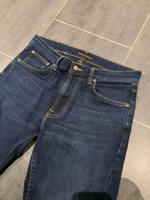 Nudie Jeans Lean Dean New Ink - Tjena säljer dessa jätte snygga och knapp använda nudie jeansen i Lean Dean modell new ink. På byxorna står det w30/L30, skulle dock säga att de är längre än det så typ w31/L32. Men passar både och. Skriv gärna vid intresse!