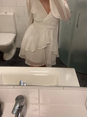 Vit klänning med volanger - går att knyta runt midjan, använd en gång