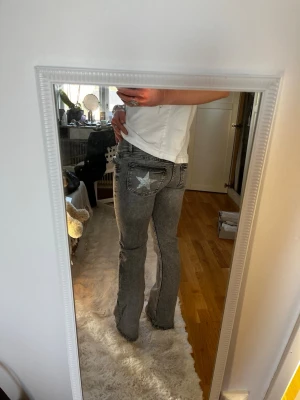 Grå bootcut jeans med stjärna - Säljer ett par grå bootcut jeans med cool stjärndetalj på bakfickan. Köpt på Gina Young, har xs i vanliga fall men dessa passar mig💞strl 158