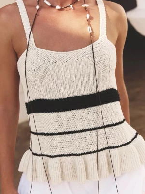 Stickad linnetopp med volangkant - Superfin stickad linnetopp i vitt med svarta ränder och volangkant nertill. Toppen har breda axelband och är ärmlös, perfekt för varma dagar. 