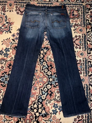 7 for all mankind lågmidjade jeans  - Säljer ett par klassiska blå jeans från 7 For All Mankind med bootcut passform. Midjemått 38cm och Innerbenslängden 75cm💕
