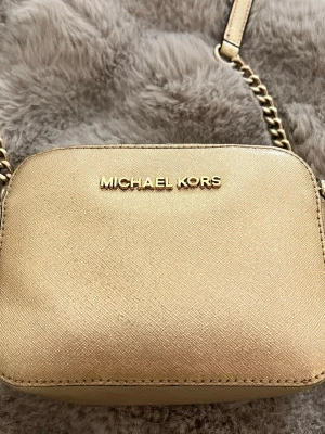 Michael kors väska - Intressekoll på denna super snygga lilla Michael Kors väskan då jag inte använder guld tyvärr. Kan skicka exakta mått om nån vill ha. Har kort hållare inuti. Hör av er vid frågor!☺️
