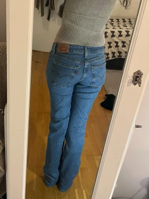 Levi's bootcut jeans  - Säljer ett par lågmidjade jeans från Levis i storlek 25w, burkar ha 27w men de är väldigt stretchiga skulle passa dig som brukar vara mellan 26-28w. De är endast använda 1-2 gånger och är i princip nyskick. Nypris:949kr. Jag är 170cm. Midjemått tvärsöver: 35cm Innerbenslängd: 83cm 