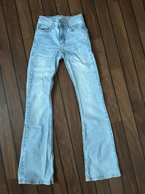 Ljusblå Gina Tricot bootcut jeans - Snygga ljusblå jeans med klassisk bootcut-passform. Jeansen har fem fickor, normal midja och är tillverkade i denim.