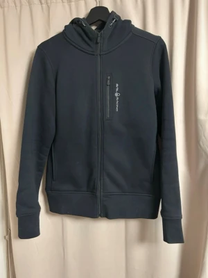 Svart hoodie från Sail Racing - Fint skick. Använd ett fåtal gånger 