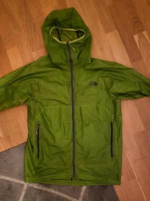 Grön vindjacka från The North Face - Mycket fin, pytte hål har markerats och en pyttefläk. Inget som märks.  Storlek S