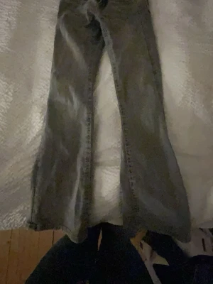 Grå bootcut jeans med låg midja - Snygga grå bootcut jeans med låg midja och klassisk femficksdesign. Jeansen har en rak passform över låren och utsvängda ben. Perfekta till sneakers eller boots för en avslappnad look.