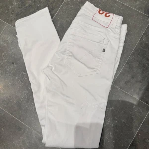 Vita Dondup George jeans  - Säljer dessa riktigt feta Jeansen från Dondup som bara är använda ett fåtal gånger eftersom att de blev för små, modellen är ”George skinny fit” dem är riktigt sköna och har en bra passform. de är tillverkade i bomull med lite stretch för extra komfort. Perfekta för dig som gillar en clean och fräsch look. Pris är ej hugget i sten, bara att höra av dig vid funderingar!🤩🤩