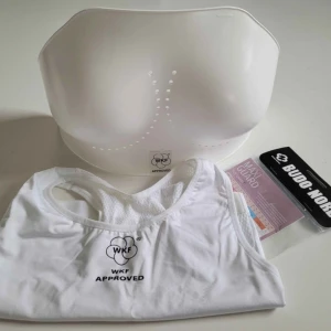 WKF Budo Nord bröstskydd och sporttop - WKF bröstskydd (399kr i butik) med tillhörande WKF sporttop (595kr i butik).  Från Budo Nord. Oanvända/nya då det var min extrauppsättning som aldrig använts. 