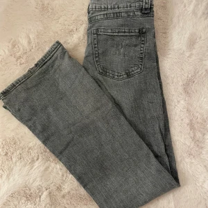 Grå bootcut jeans - Snygga grå jeans med klassisk femficksdesign och bootcut. Jeansen har en enkel bakficka och är tillverkade i ett mjukt denimtyg som ger en avslappnad vibe. Storlek 154, motsvarar XXS