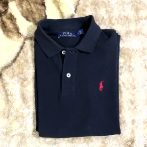 Svart pikétröja från Ralph Lauren S - Klassisk svart pikétröja från Polo Ralph Lauren Perfekt för en clean och stilren outfit! 