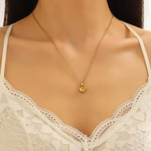 Guldigt halsband med hjärthänge - Ett elegant halsband i guld med ett litet hjärta som hänge. Kedjan är tunn och smidig, vilket gör att hjärtat verkligen står i fokus. Perfekt accessoar för att lyfta vilken outfit som helst.