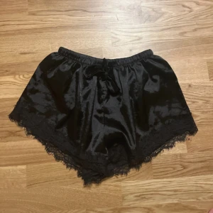 Svarta silkesshorts  - Svarta silkesshorts med spets i strl M/L. Det är i mycket bra skick och är använda en gång.