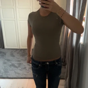 Tight T-shirt från hm - Säljer min grön/gråa tshirt från hm då jag aldrig använt den, modellen är slimmed, passar bra både till träning och vardag, nypris 150 kr