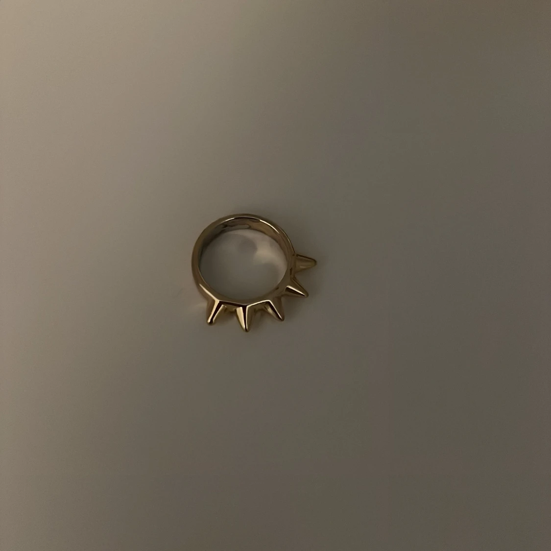 Guldig ring med taggiga detaljer