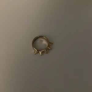 Guldig ring med taggiga detaljer - Cool ring i guldton med unika taggiga detaljer runt om. Ringen har en edgy och modern design som verkligen sticker ut och passar perfekt för dig som vill ha något annorlunda. Snygg accessoar som ger din stil en extra attityd.