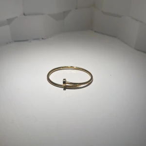 Guldfärgat armband med spikdesign - Coolt armband i guldfärg med unik spikformad design. Stilren och minimalistisk look som sticker ut och passar perfekt för dig som gillar edgy detaljer. Armbandet är runt och har en snygg metallfinish.