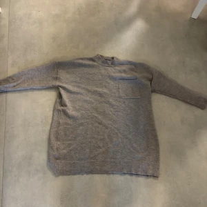 Beige stickad tröja från Esmara - Mysig beige stickad tröja från Esmara i storlek L. Tröjan har långärmad design, ribbad hals och muddar samt en praktisk bröstficka. Perfekt för dig som gillar enkel och chill stil med lite extra längd. Den är använd så lite nopprig men i fint skick.