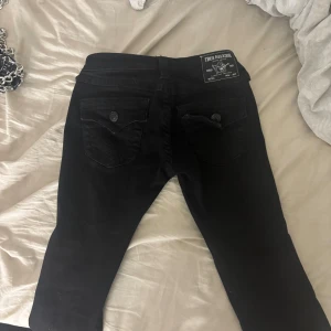 True Religion Joey Low Rise Flare jeans - Svarta jeans från True Religion, modell Joey Low Rise Flare. Snygg låg midja och utsvängda ben med klassiska fickor bak med knappstängning. Aldrig använda 