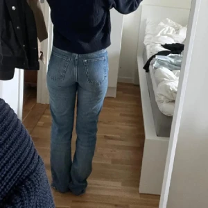 blå jeans straight fit - Klassiska blå jeans med rak passform och hög midja. Jeansen har fem fickor, knappgylf och är tillverkade i robust denim. Perfekta för dig som gillar en tidlös och avslappnad stil.